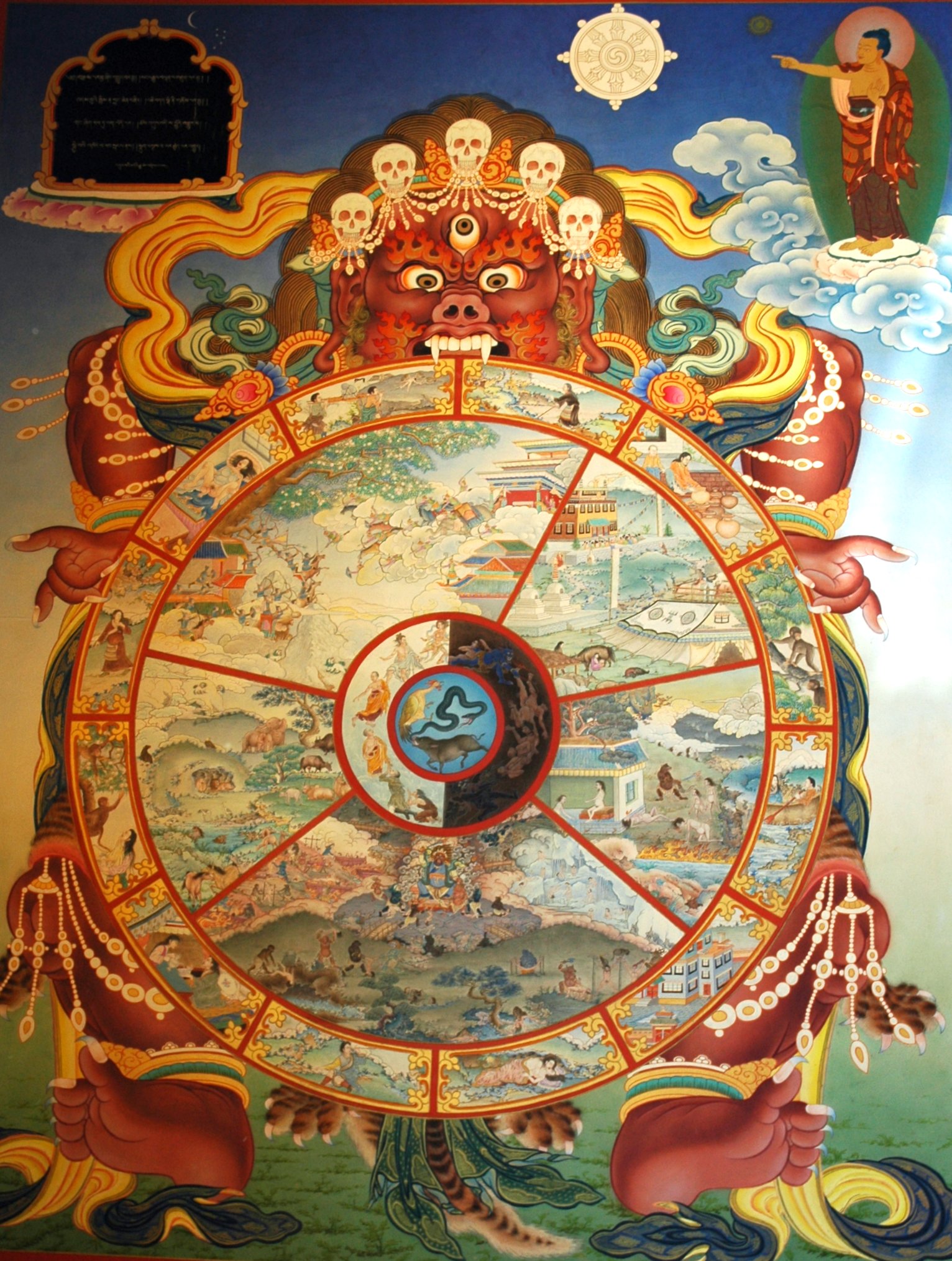 https://upload.wikimedia.org/wikipedia/commons/4/40/Traditional_bhavachakra_wall_mural_of_Yama_holding_the_wheel_of_life%2C_Buddha_pointing_the_way_out.jpg